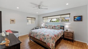 A bedroom with a bed, nightstands, a ceiling fan, and a window with a view of greenery. - 25% Off Sept 3-6! Mins 2 Beach, Rooftop Patio View (Oxnard)