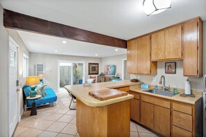 A kitchen with wooden cabinets, a central island, and a sink.