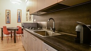Una cocina moderna con estufa a gas, pileta de acero inoxidable y cafetera.