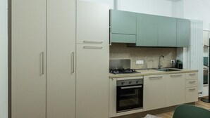 Een keuken met een gasfornuis, oven, spoelbak en kasten.
