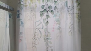 A bathroom with a white shower curtain featuring a floral pattern. - Kinamara Ensuite Room (Margate)
