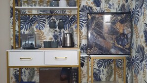 A kitchen with a microwave, toaster, and cabinets, and a television on the wall. - Kinamara Ensuite Room (Margate)