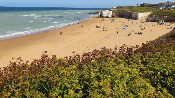 A beach with cliffs, a lifeguard tower, and a clear sky. - Kinamara Ensuite Room (Margate)
