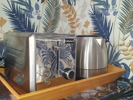 Een keuken met een broodrooster en koffiezetapparaat op een houten dienblad.