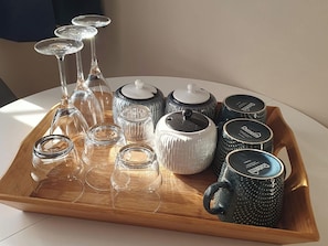 A tray with various glassware and ceramic containers on a table.