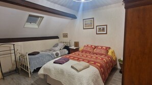 A bedroom with two beds, a window, and framed pictures on the wall. - "African" Room, ideal for sporting events at the Le Mans circuit (Le Mans)
