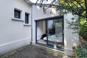 Uma casa moderna com porta de vidro deslizante que dá para um quarto com cama e escada.