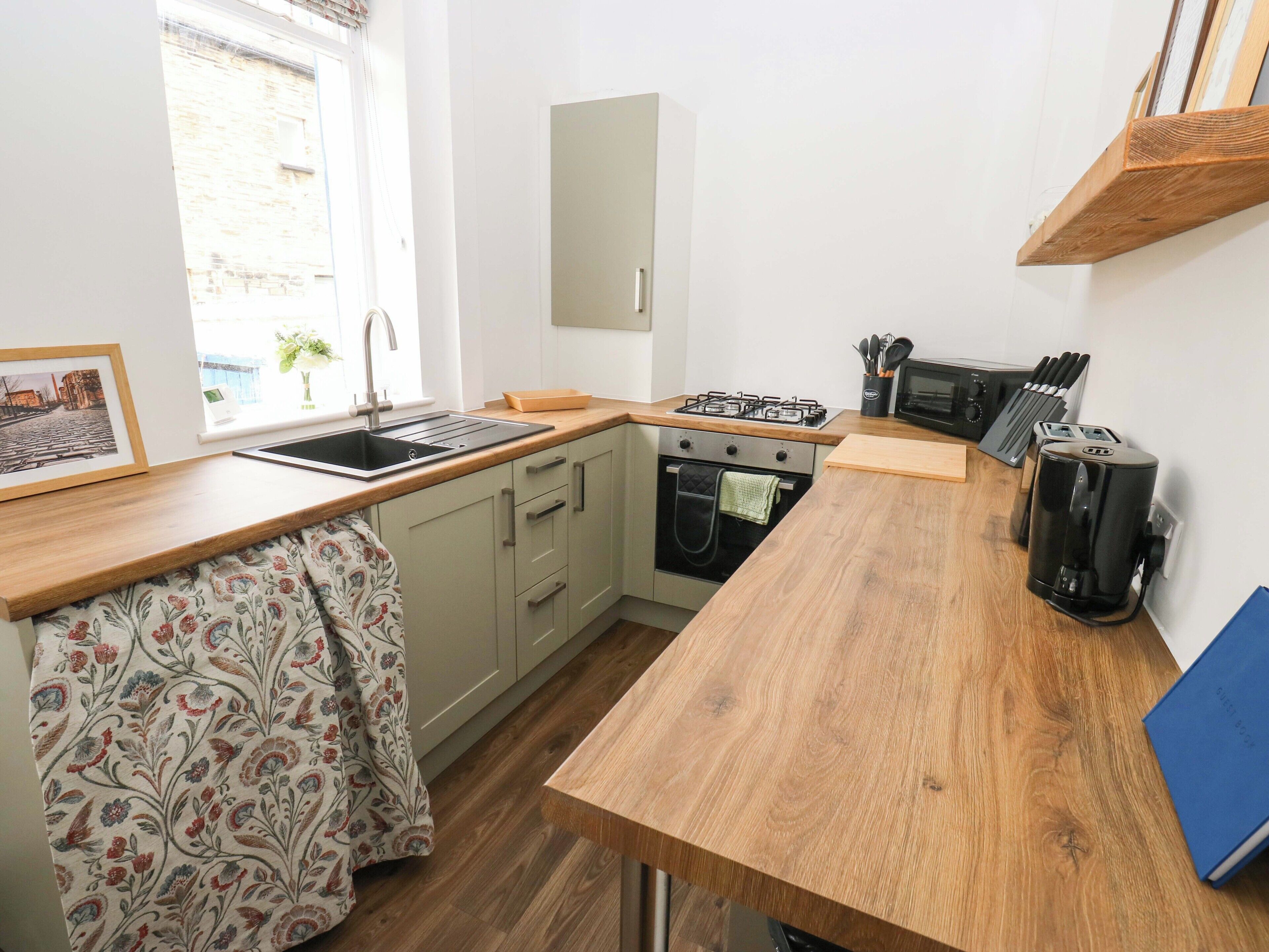 A compact kitchen with a sink, stove, oven, and microwave.