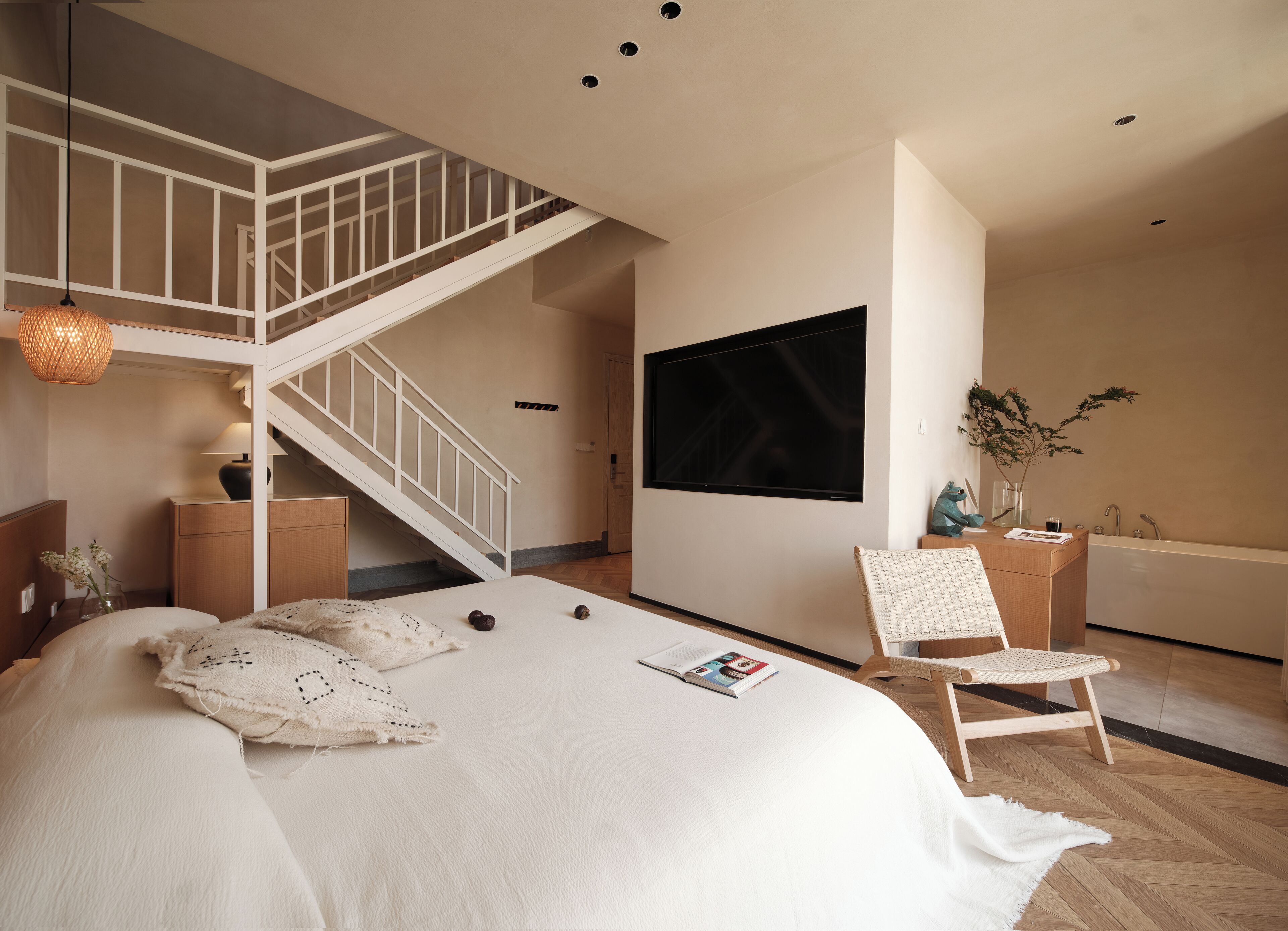 Une chambre à coucher comprenant un lit, une chaise, un téléviseur, un escalier et une salle de bain.