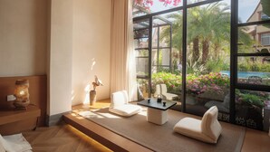 A modern room with a large window, a sofa, a small table, and a decorative lamp.