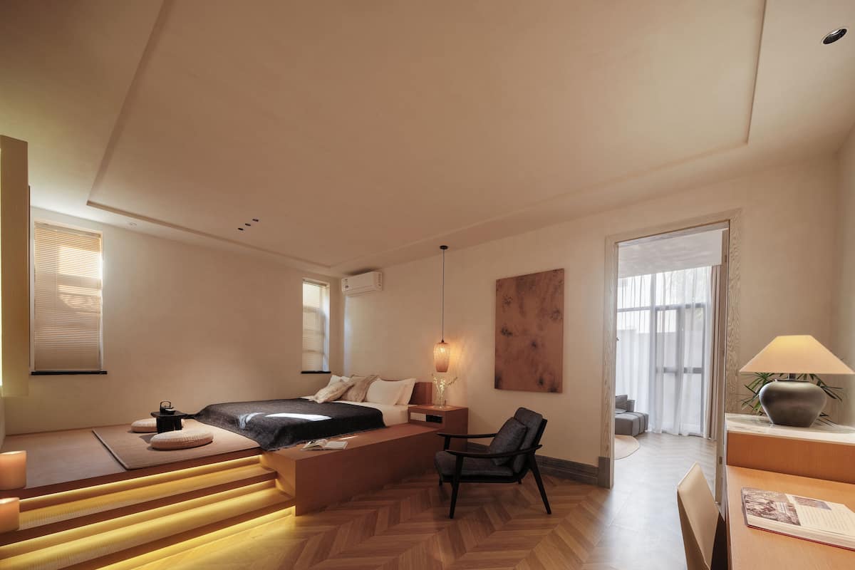 Et moderne hotelværelse med seng, siddeplads og skrivebord.