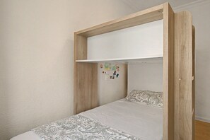 Cama litera con estructura de madera y literas superiores blancas.