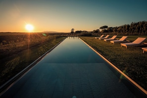 A swimming pool with lounge chairs and a clear view of the sunset. - Terre di Sacra Ville & Cottage (Capalbio)