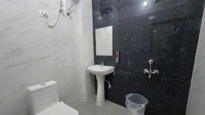 Een badkamer met toilet, wastafel en douche.