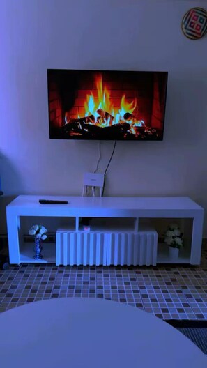 A television mounted on a wall with a white entertainment unit below. - Cozy 1BR Home Away From Home with Balcony Near TRM Mall and Garden City (Nairobi)