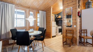 Un interior de madera con comedor, cocina y un espejo.