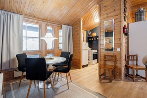 A wooden interior with a dining area, kitchen, and a mirror. - Newly Renovated 2BR Cabin in Riihivuori (Muurame)