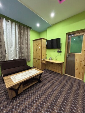 A room with a bed, a desk, a television, and a wardrobe.