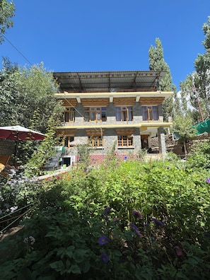A two-story building with a flat roof, multiple windows, and a balcony.