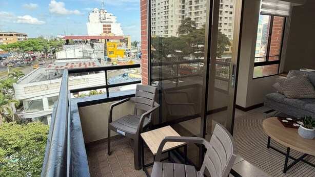 Un balcon avec une table, des chaises et un canapé.