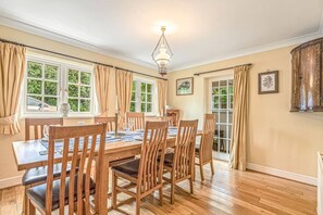 Ein Esszimmer mit Holztisch, Stühlen und einer Chandelier.
