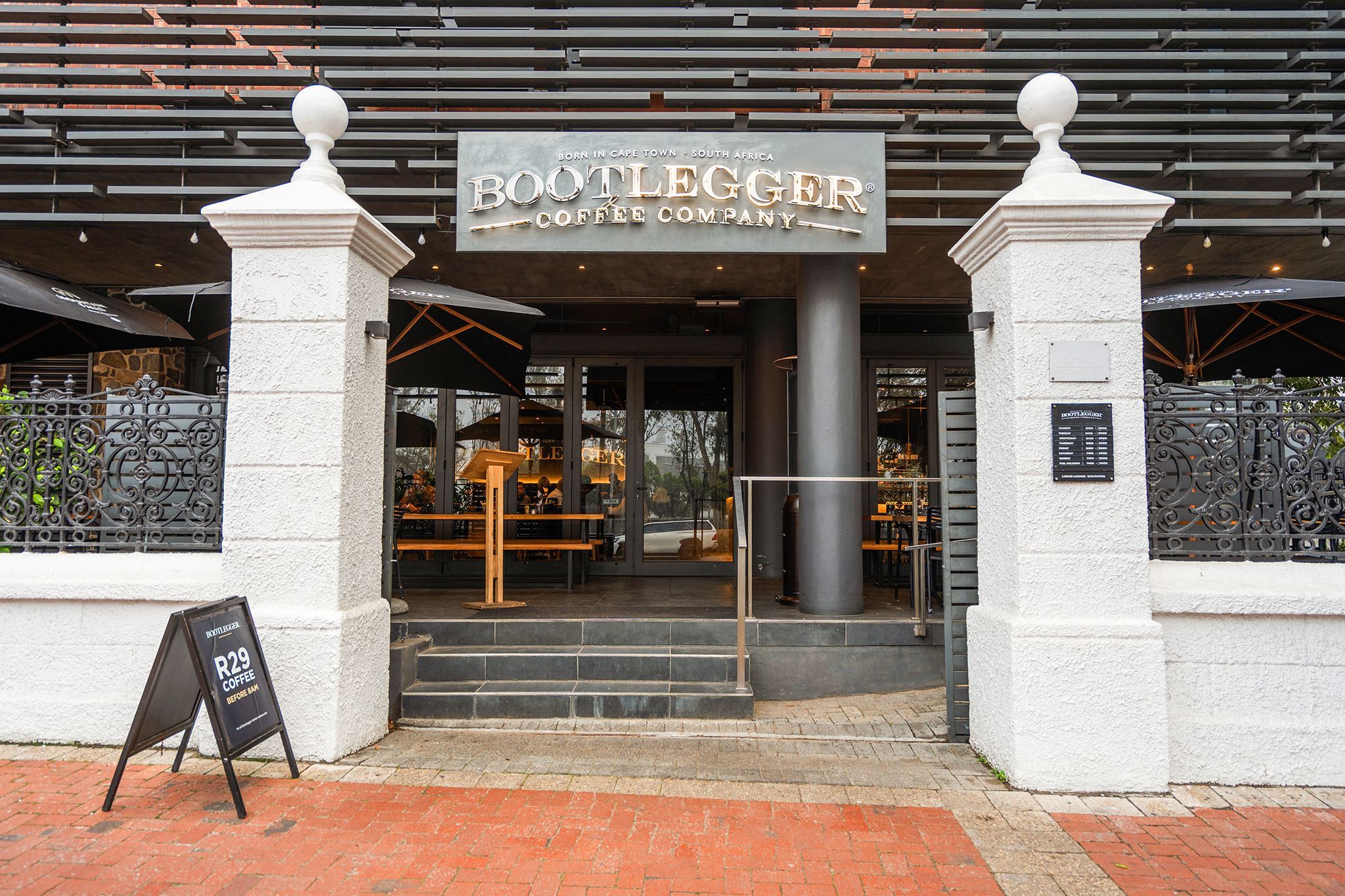 Exterior de Bootlegger Coffee Company, con entrada despejada, escalones que conducen a la puerta y un cartel sobre la entrada.