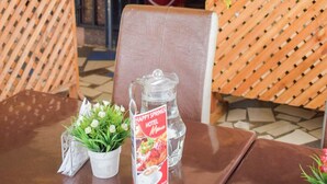Un restaurante con un separador de madera entrecruzada, una mesa con un menú y un cartel del Hotel Happy Springs.