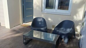 A glass-top table with two chairs outside a building.