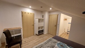 Une pièce comprenant un bureau, deux armoires, une commode et un tapis à motifs.