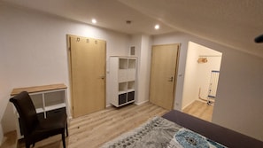 A room with a desk, two wardrobes, a chest of drawers, and a patterned rug. - Apartment Abel with Balcony, Wi-Fi and Air Conditioning (Oldenburg)
