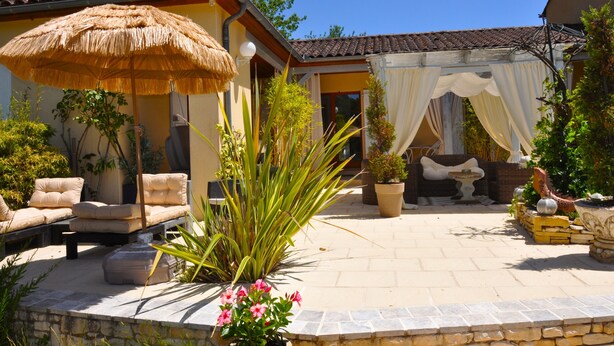 A patio with outdoor furniture, a thatched umbrella, and potted plants. - O Reflection of the Lake (Groléjac)