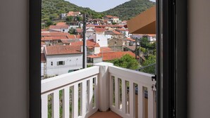 A balcony with a view of a town and hills.
