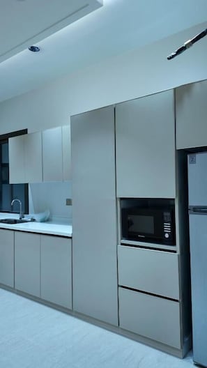 A modern kitchen with built-in appliances, a sink, and cabinets.