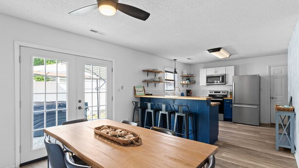 Une cuisine moderne dotée d’un îlot central, de tabourets de bar et d’une table à manger avec des chaises.