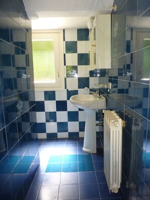 A bathroom with a checkered tile pattern, a sink, a mirror, and a radiator. - Holiday Home 'Cascinetta' with Mountain View, Private Garden and Wi-Fi (Castello)