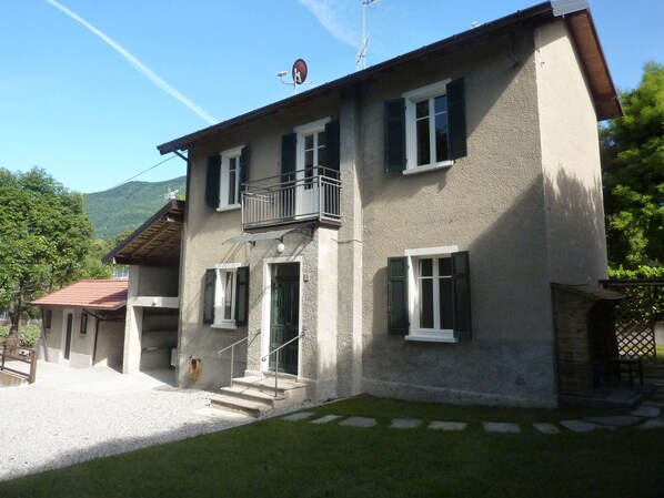 A two-story building with a balcony, a satellite dish, and a small garden area. - Holiday Home 'Cascinetta' with Mountain View, Private Garden and Wi-Fi (Castello)