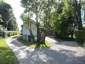 A house with a paved driveway, surrounded by trees and a well-maintained lawn. - Holiday Home 'Cascinetta' with Mountain View, Private Garden and Wi-Fi (Castello)