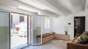 Una sala de estar moderna con un ventanal corredizo que da a un área de estar exterior.