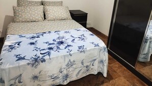 Ein Schlafzimmer mit Bett, Nachttisch und Kleiderschrank.