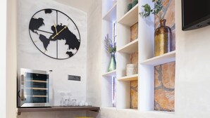 A modern kitchen with a built-in oven, a yellow stool, and a wall-mounted clock. - Hygge Rooms Split (Split)