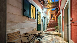A narrow alleyway with a bench and table, a staircase, and a building with a tiled floor. - Hygge Rooms Split (Split)
