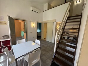 Un intérieur moderne comprenant un coin repas, un escalier et une buanderie à aire ouverte.