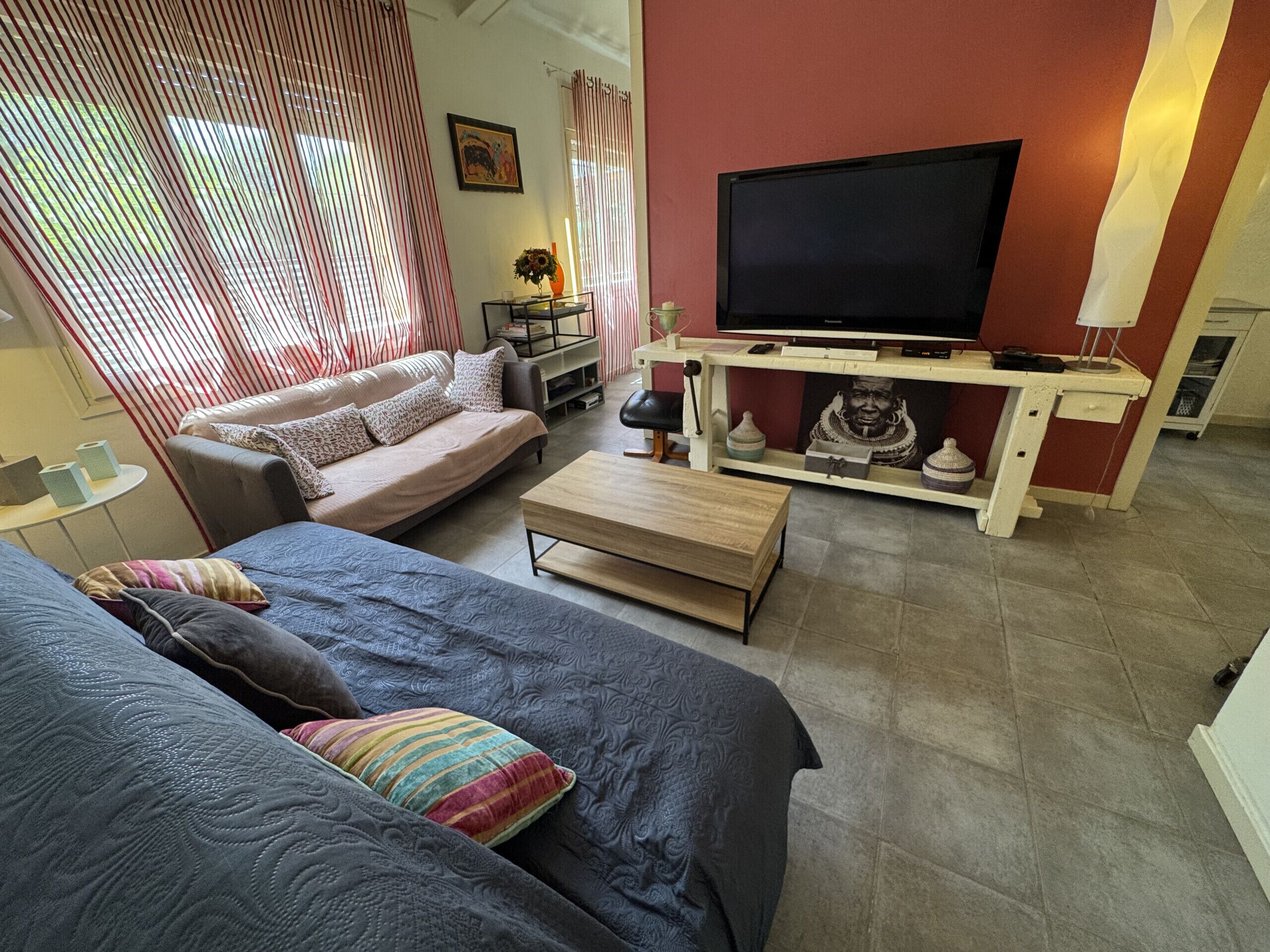 Una sala de estar moderna con un sofá, una mesa de centro, un televisor y una estantería decorativa.