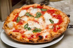 Una pizza sobre un plato blanco.