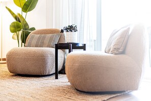 A living room with two armchairs, a small table, and a potted plant. - Marina Garden View in Lagos (Lagos)