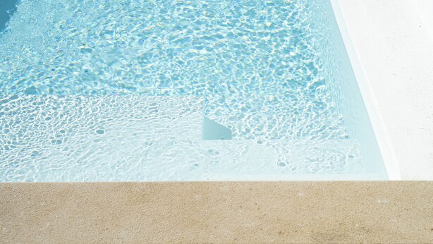 A clear pool with a sandy bottom and a white edge. - Casa Oliva Refúgio Rural Contemporâneo (Salvada)