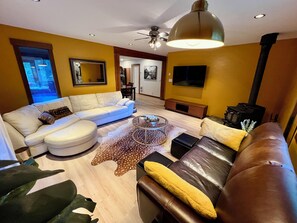 A living room with a sofa, coffee table, and a fireplace. - Valhalla Cottage, hunters or skiers dream! Slocan Valley’s sweet spot! (Central Kootenay H)