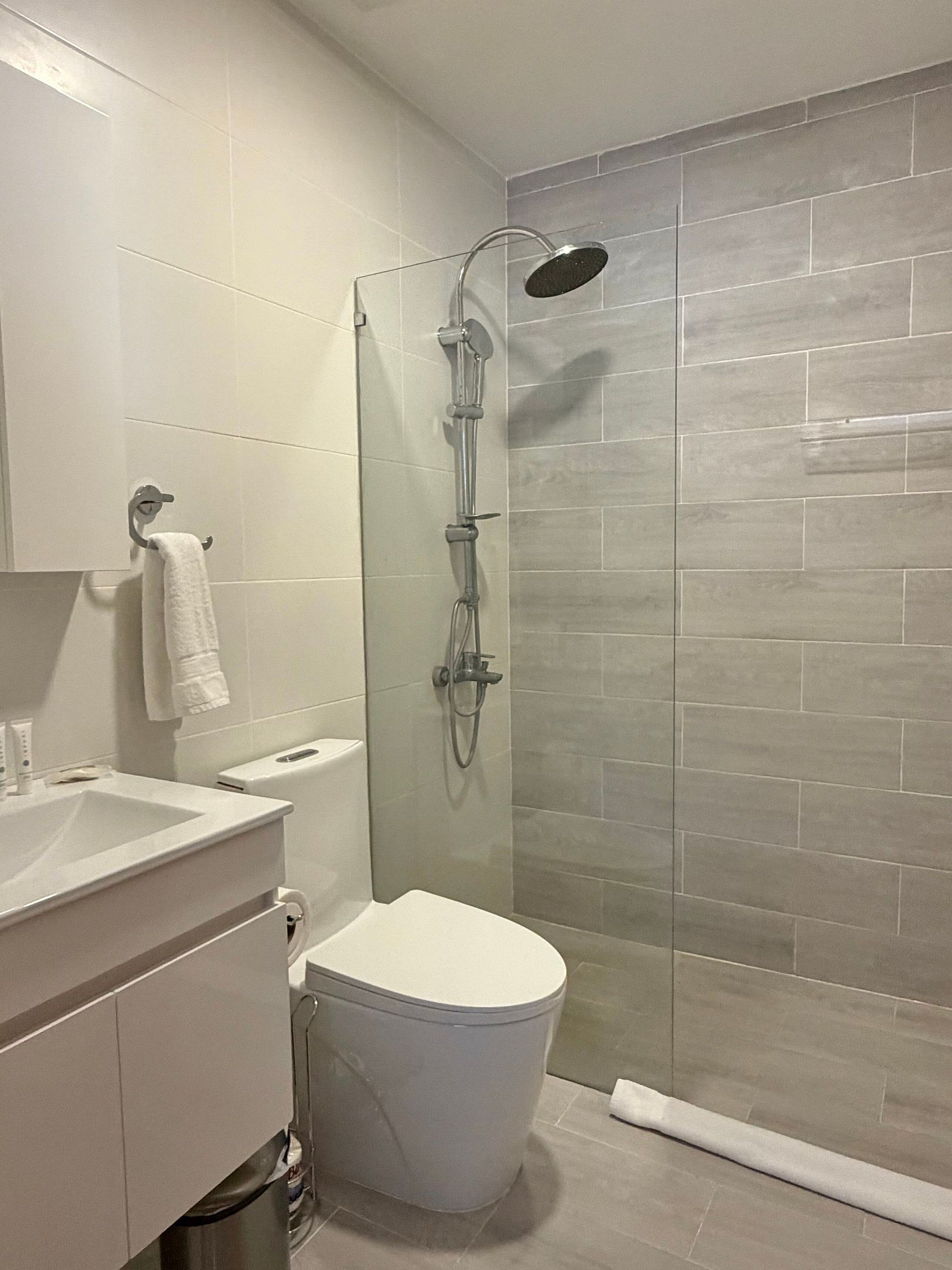 Un baño moderno con ducha, inodoro y lavamanos.