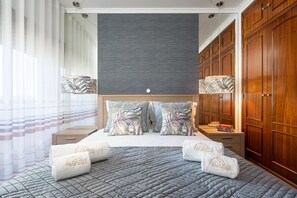 A hotel room with a bed, wooden wardrobe, and a nightstand with a lamp. - Sea La Vie | On the Beach, City Center & Marina (Lagos)