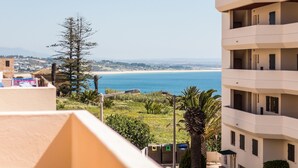 Un immeuble à plusieurs étages doté de balcons donnant sur un paysage côtier.